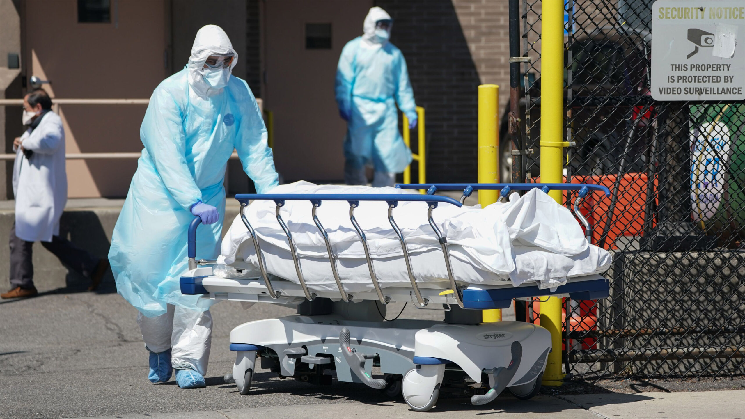 Bodies are moved to a refrigeration truck serving as a temporary morgue at Wyckoff Hospital in the Borough of Brooklyn on April 6, 2020 in New York. - New York Governor Andrew Cuomo on Monday extended a shutdown in the epicenter of America's deadly coronavirus pandemic until near the end of the month. Cuomo said the COVID-19 death rate in New York was "effectively flat" for the past two days but announced that schools and non-essential businesses must stay shut until April 29. (Photo by Bryan R. Smith / AFP) (Photo by BRYAN R. SMITH/AFP via Getty Images)