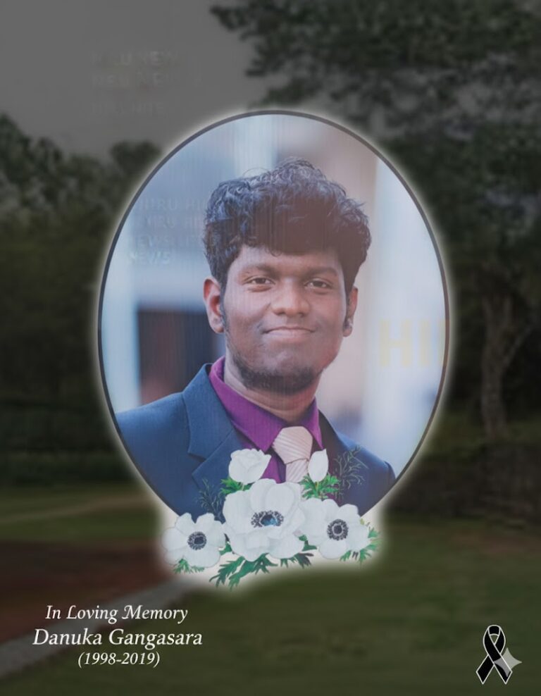 Commemorative feature image for the article: A portrait of Danuka Gangasara, a smiling young man in a dark suit and purple shirt, set in an oval frame with white memorial flowers, and the text "In Loving Memory - Danuka Gangasara (1998-2019)" overlaying the bottom corner.